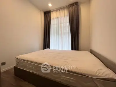 Cozy bedroom with large bed and elegant curtains, perfect for relaxation.