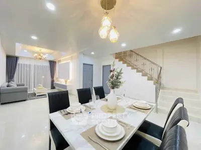 Luxurious open-plan living and dining area with elegant decor and modern lighting