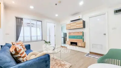 Modern living room with stylish decor and wall-mounted TV in a cozy apartment.