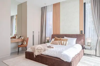 Luxurious bedroom with elegant decor and natural light, featuring a plush bed and stylish vanity area.