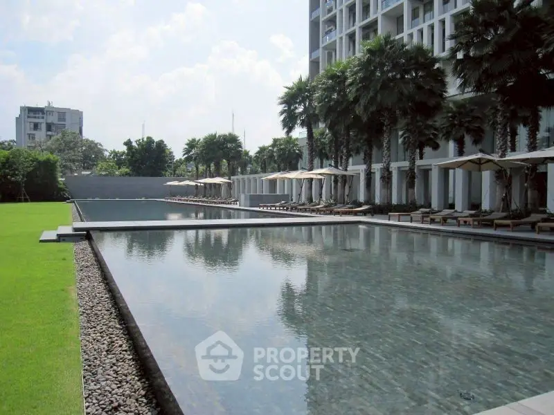 Luxurious poolside area with modern architecture and lush greenery, perfect for relaxation and leisure.
