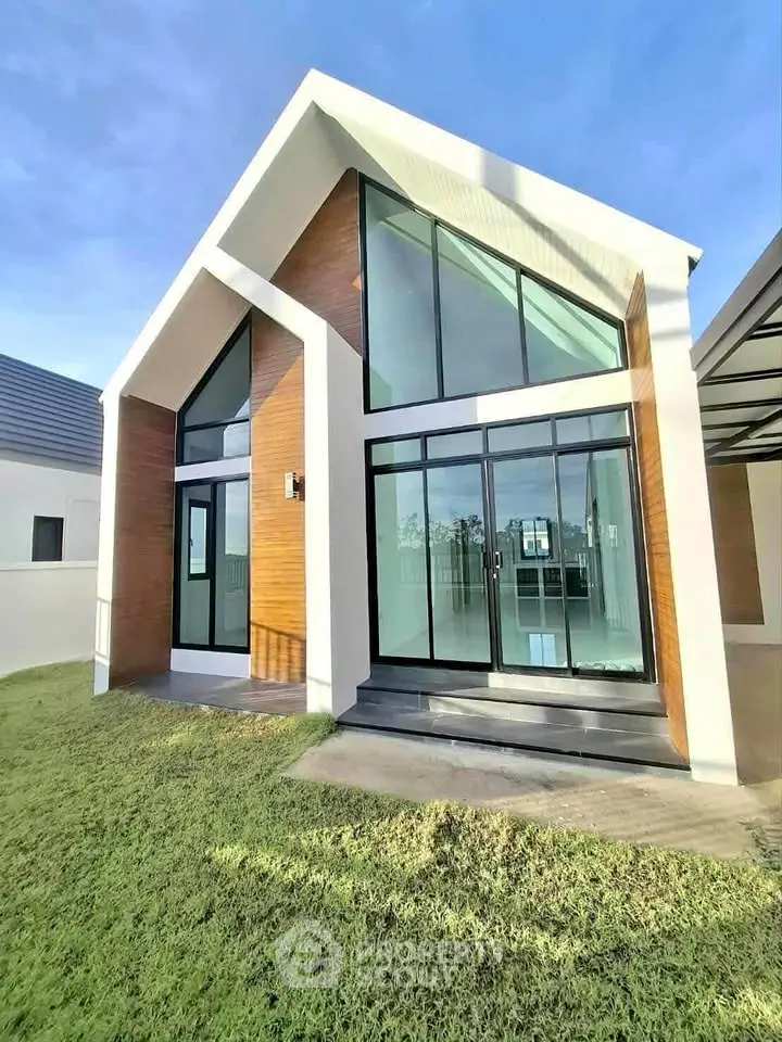 Modern minimalist house with large glass windows and wooden accents, perfect for natural light lovers.