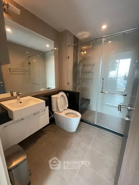 Modern bathroom with glass shower and sleek fixtures in a contemporary apartment.