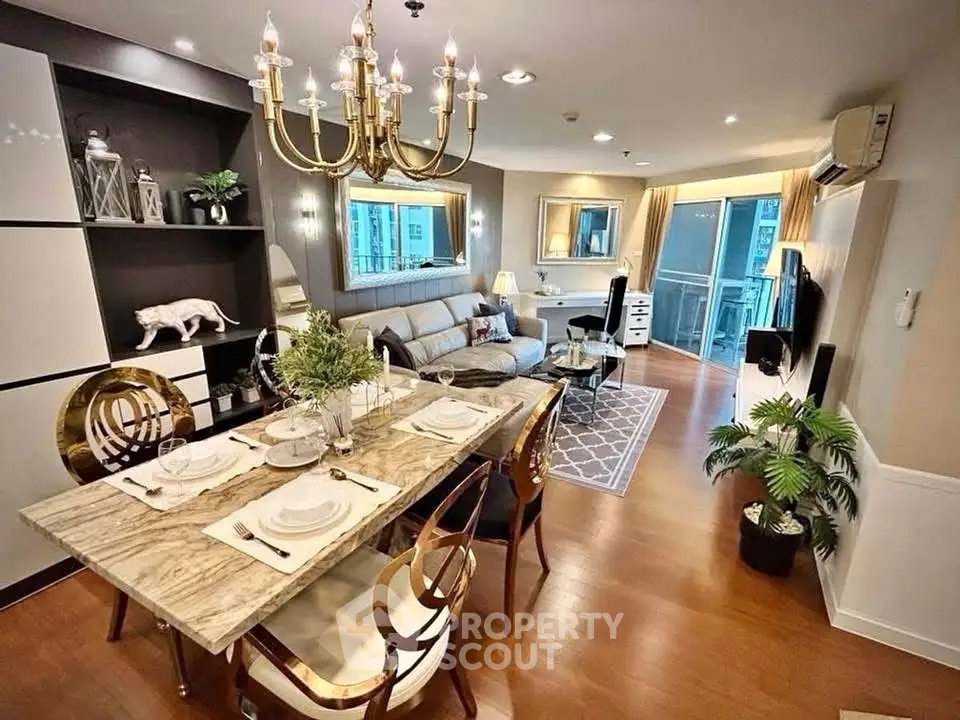 Luxurious open-plan living and dining area with elegant chandelier and modern decor.