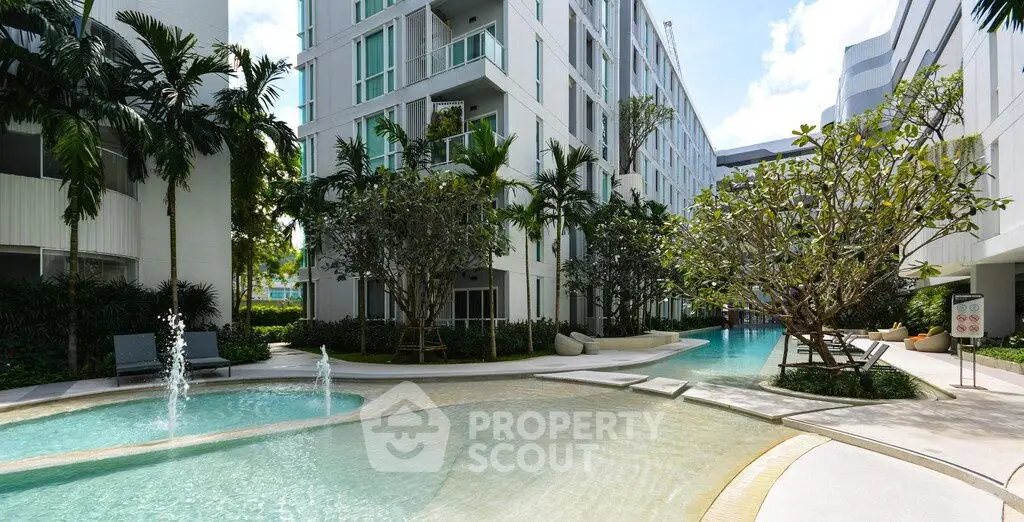 Luxurious modern apartment complex with stunning pool and lush greenery.