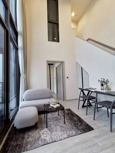 Modern living room with high ceilings and stylish furniture in a contemporary apartment.