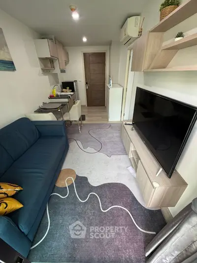 Modern living room with stylish decor, featuring a blue sofa, wall-mounted TV, and contemporary shelving.