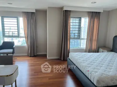 Spacious bedroom with city view and elegant hardwood flooring