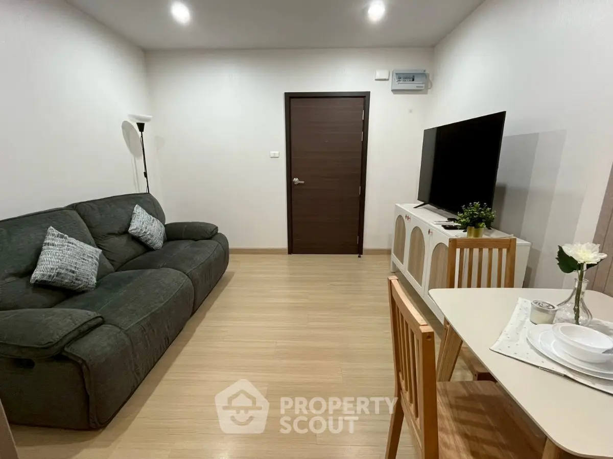 Cozy living room with modern decor, featuring a plush sofa and sleek dining area, perfect for relaxation and entertaining.