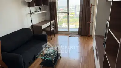 Modern living room with balcony view, sleek furniture, and wooden flooring in a high-rise apartment.