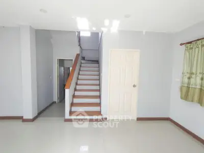 Spacious interior with staircase and door, ideal for modern living.
