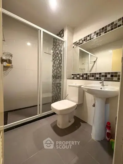 Modern bathroom with glass shower and sleek fixtures in a contemporary home.