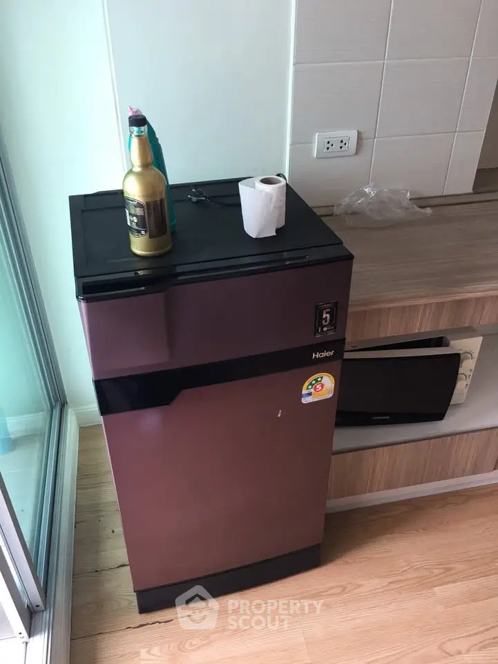 Compact kitchen corner with modern fridge and wooden flooring