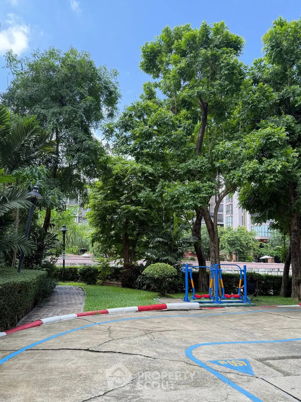 Lush garden area with outdoor fitness equipment in a residential complex.