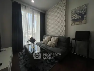 Chic living room with modern decor, featuring a stylish sofa, elegant wall art, and floor-to-ceiling windows.