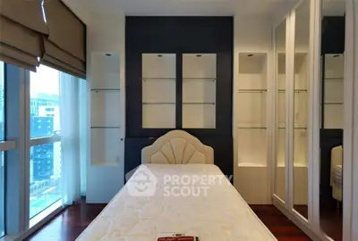 Modern bedroom with built-in shelves and large windows offering city views.