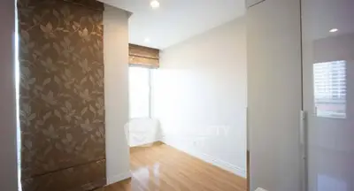 Bright empty room with wooden flooring and large window, ideal for customization.