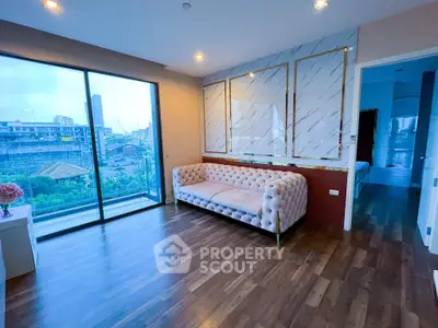 Modern living room with elegant sofa and large windows offering city view