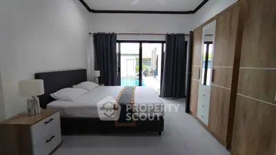 Spacious bedroom with pool view and modern furnishings