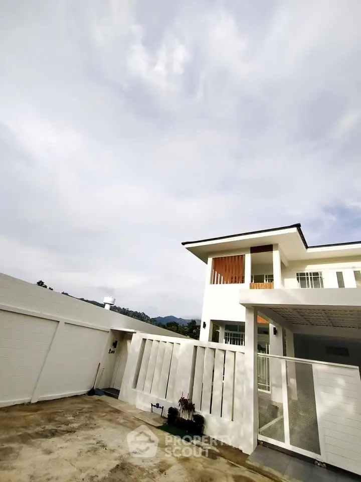 Modern two-story white house with spacious driveway and clear sky view.