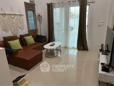 Modern living room with brown leather sofa, stylish decor, and natural light from large window.