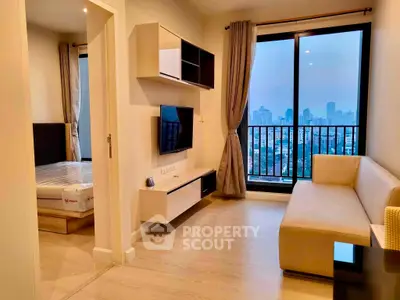 Modern living room with city view, featuring sleek furniture and large windows for natural light.
