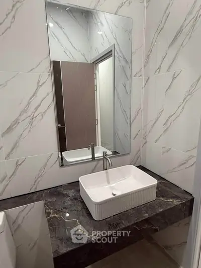 Modern bathroom with marble tiles and sleek rectangular sink