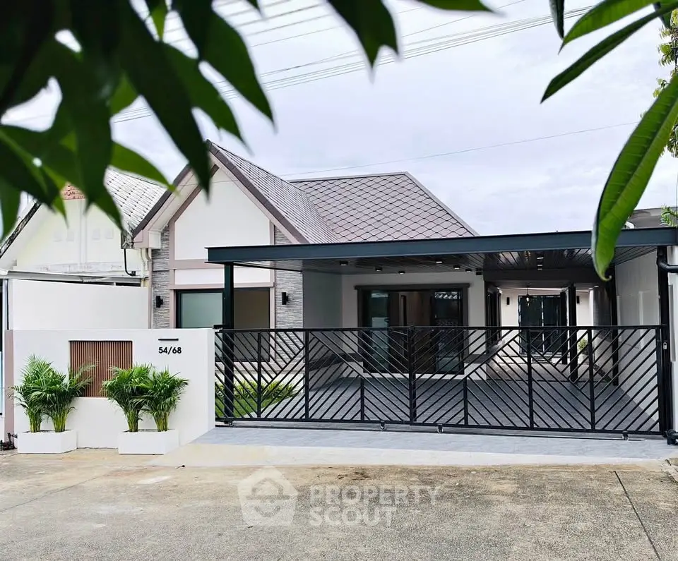 Modern house exterior with sleek gate and driveway, surrounded by lush greenery, showcasing contemporary architecture.
