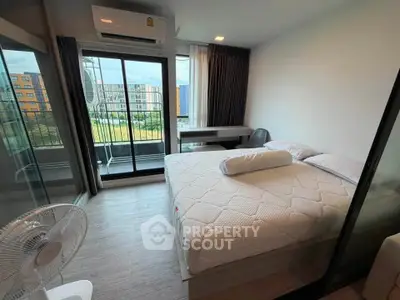 Modern bedroom with balcony view in urban apartment, featuring air conditioning and stylish decor.