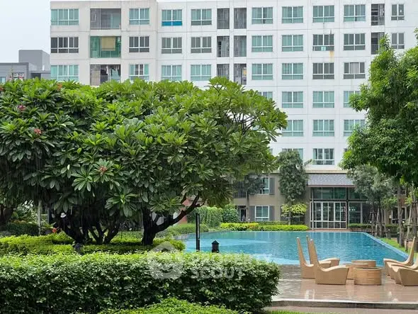 Luxurious apartment complex with serene pool and lush greenery, perfect for relaxation and modern living.