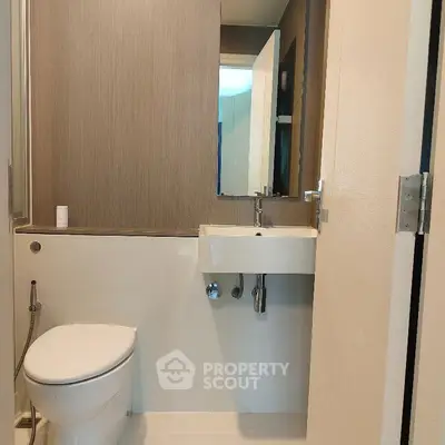 Modern minimalist bathroom with sleek fixtures and neutral tones.