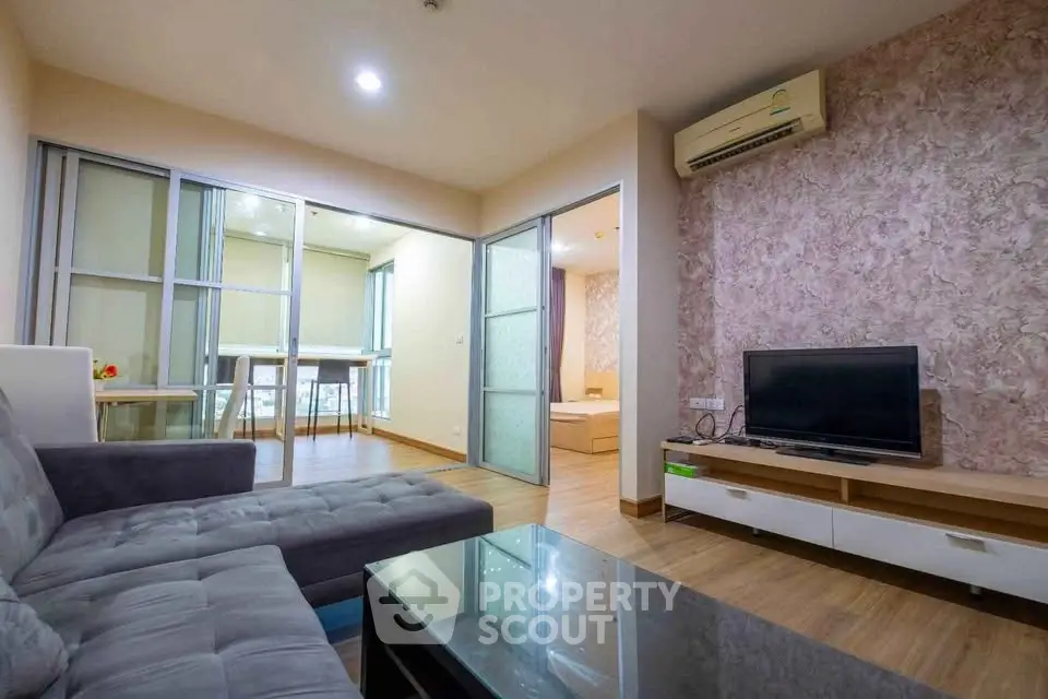 Modern living room with stylish decor and open layout, featuring a cozy sofa and sleek entertainment unit.