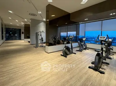 Spacious modern gym with city view in luxury residential building