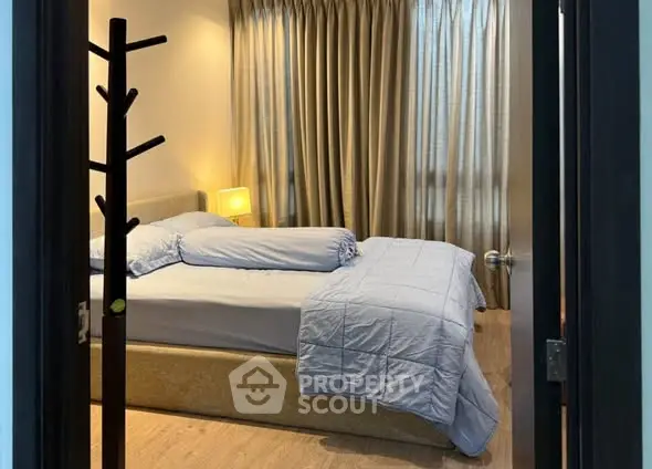 Cozy bedroom with elegant curtains and soft lighting, perfect for relaxation.