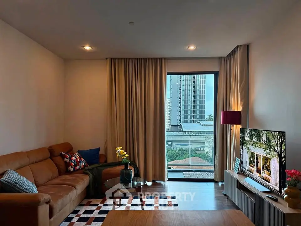 Modern living room with leather sofa, stylish decor, and city view through large window.