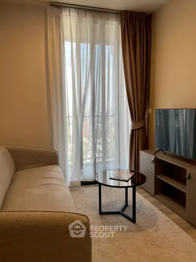 Cozy living room with modern sofa, TV, and balcony view