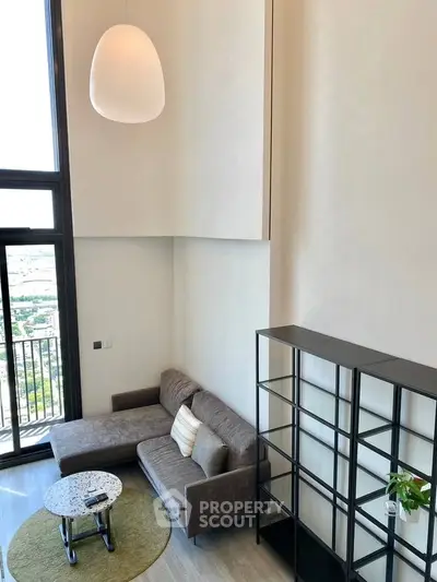 Modern high-ceiling living room with large windows and stylish furniture