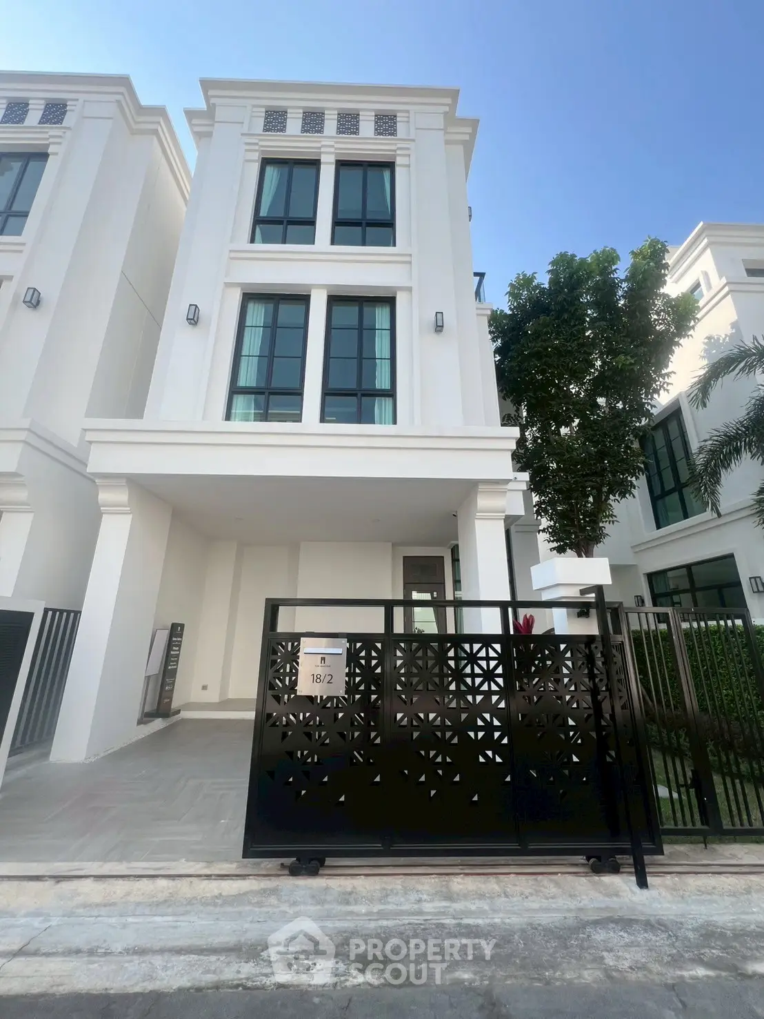 Elegant modern townhouse with sleek facade and gated entrance in a desirable neighborhood.