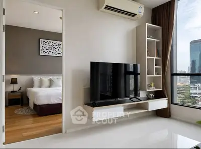 Modern living room with sleek TV setup and city view, adjacent to cozy bedroom.