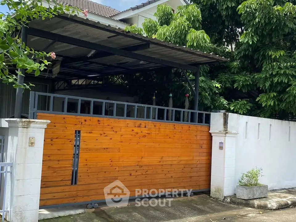 Charming residential entrance with wooden gate and lush greenery