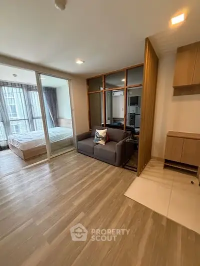 Modern apartment with open layout and wooden flooring, featuring a cozy living area and bedroom.