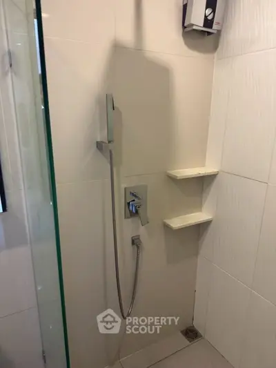 Modern bathroom shower area with sleek fixtures and built-in shelves