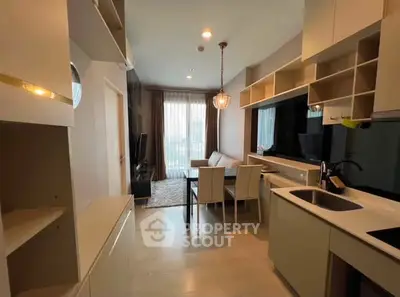 Modern open-layout kitchen and living room with stylish decor and natural light.