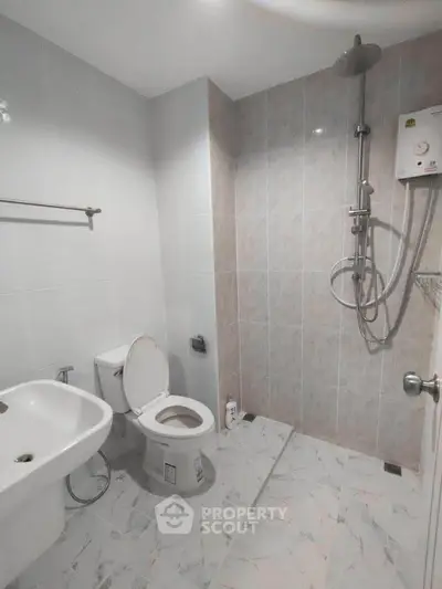 Modern bathroom with shower and toilet in sleek white design