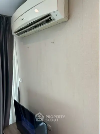Modern living room with air conditioning and flat-screen TV, perfect for comfortable living.