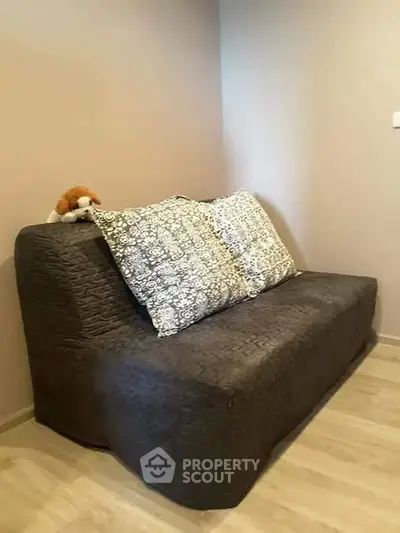 Cozy small living room with a stylish sofa and decorative pillows.