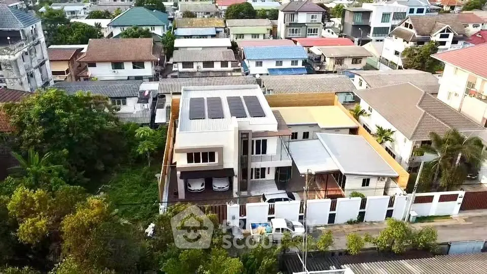 Aerial view of suburban neighborhood with modern houses and lush greenery.