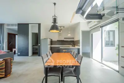 Modern open-plan living and dining area with sleek kitchen and abundant natural light.