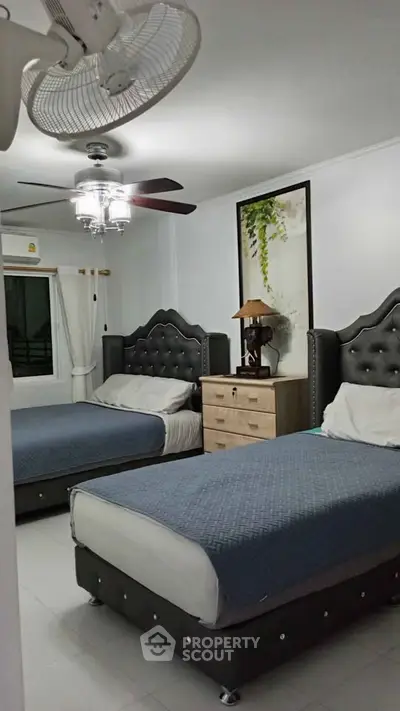 Spacious bedroom with two elegant beds and modern decor in a cozy apartment.
