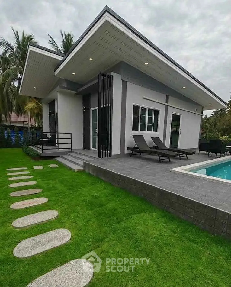 Modern single-story home with sleek design, pool, and lush garden, perfect for luxury living.